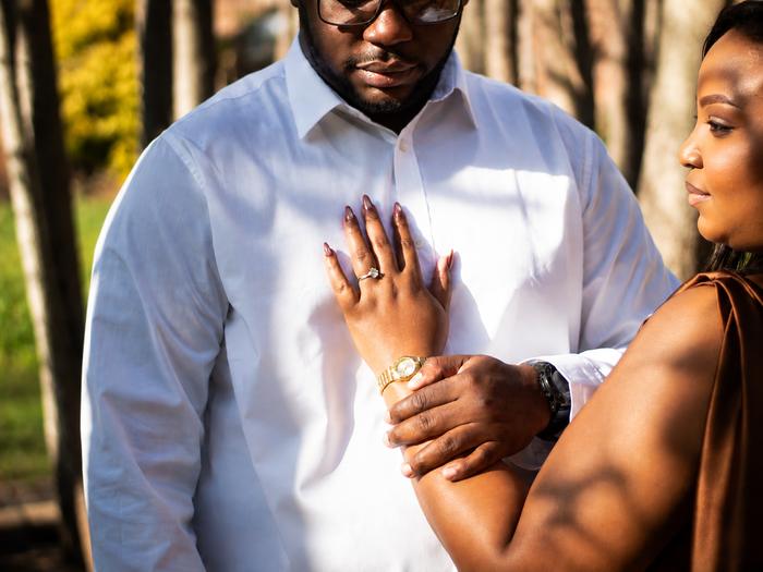 Hand resting over the heart, engagement ring in view
